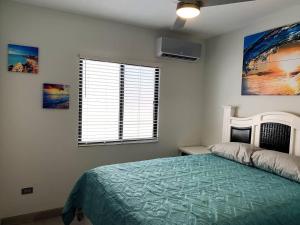 1 dormitorio con cama y ventana en Casita de Moana, en Puerto Peñasco