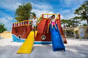 Un ragazzo e una ragazza su uno scivolo in un parco giochi di Simpson Bay Resort Marina & Spa a Simpson Bay