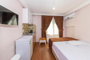 イスタンブールにあるTavra hotelのベッド2台とキッチンが備わる小さな客室です。