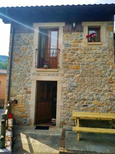 a stone building with a bench in front of it at Casa de Aldea La Xunta in Cangas de Onís