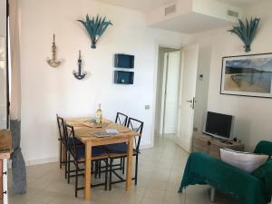 a dining room with a table and chairs and a television at Case Vacanza Mare Nostrum in Torre delle Stelle