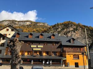a large building in front of a mountain at Hotel Sarao in Escarrilla