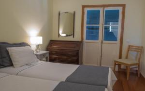 a bedroom with a bed and a dresser and a mirror at Apartments Madeira Santa Maria in Funchal