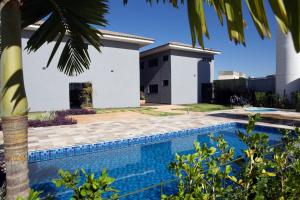 a villa with a swimming pool in front of a house at Regional Plaza Hotel Event Park in Jales