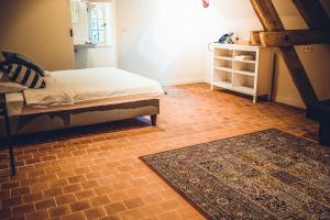 ein Schlafzimmer mit einem Bett und einem Teppich auf dem Boden in der Unterkunft Colonie 7 - Gastenkamers in Merksplas