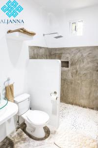 a white bathroom with a toilet and a sink at Aljanna House in Bacalar