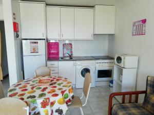 a kitchen with a table and a kitchen with white cabinets at Porto Seguro in Portimão