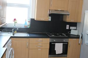 a kitchen with a sink and a stove top oven at Park Lane Heights - Self Catering - Guesthouse Style - Family and Double Rooms in Workington