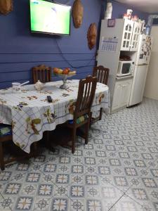 cocina con mesa y nevera en Hostal Boutique "Maryluz", en Coyhaique