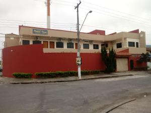 un edificio rojo y blanco al lado de una calle en Pousada Nossa Casa en Aparecida