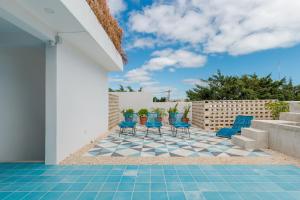 patio z niebieskimi krzesłami i podłogą wyłożoną kafelkami w obiekcie Studios Downtown Cancun w mieście Cancún