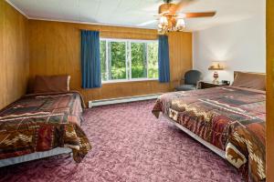 a bedroom with two beds and a window at Talkeetna Inn in Talkeetna