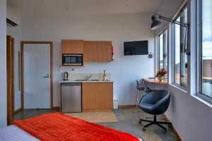 Cette chambre comprend une petite cuisine avec un bureau et une chaise. dans l'établissement Cloudscape Apartment No 2, à Kingscote