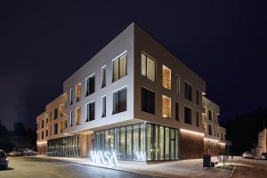 a large building with a lot of windows at night at Wasa Resort Hotel, Apartments & SPA in Pärnu