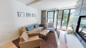 salon z kanapą, krzesłami i oknami w obiekcie White Pearl Apartment 2.05 w mieście Timmendorfer Strand
