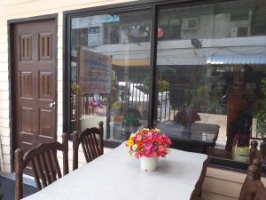 a table with a vase of flowers on top of it at OK.home@Donmuang airport in Bangkok