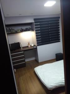um quarto com uma secretária e uma cama. em Apartamento Santana Expo Center Norte vista Top cidade de São Paulo e Paulista em São Paulo