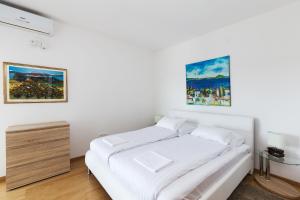 プナトにあるVilla Andreaの白いベッドルーム(ベッド1台付)が備わります。壁には絵画が飾られています。 +23枚の写真