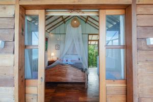 a bedroom with a bed in a room with glass doors at Pondok Pisang Candidasa in Candidasa