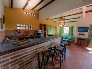 uma cozinha com um bar com cadeiras e um lavatório em Hostal La Casa de Felipe em Taganga