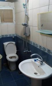 a bathroom with a toilet and a sink at Zahrate Elfirdaos Rooms للرجال فقط in Alexandria