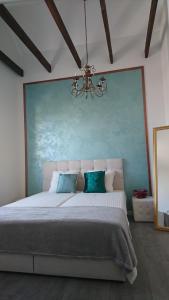 a bedroom with a large bed and a chandelier at VILLA FLORANCE apartments with terraces & parking in Ventspils