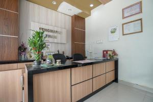 una oficina con recepción en una habitación en RedDoorz Plus near Palembang Airport 3, en Palembang