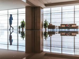 a person walking through a room with a large window at Pullman Fuzhou Tahoe in Fuzhou