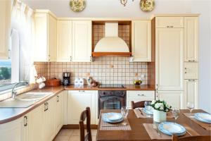 a kitchen with white cabinets and a table and a sink at Villa Aiolos in Palekastron