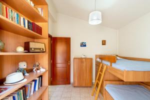 a small room with a bunk bed and bookshelves at Villa Aiolos in Palekastron