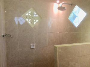 a bathroom with a shower with a glass door at Rumah Irak et Kadek Bali in Ubud