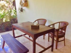 a wooden table with two chairs and a box on it at Rumah Irak et Kadek Bali in Ubud +43 photos