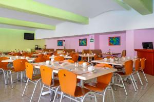 a dining room with tables and chairs and pink walls at Comfort Inn Veracruz in Veracruz