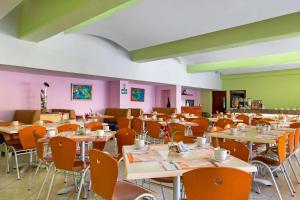 uma sala de jantar com mesas e cadeiras e paredes coloridas em Comfort Inn Veracruz em Veracruz