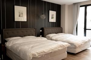 2 camas en un dormitorio con paredes negras en Grace Garden Coffee Homestay, en Shuili