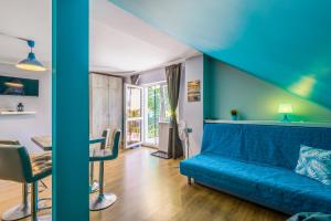 a room with a blue bed and a table and chairs at Verona in Kąty Rybackie