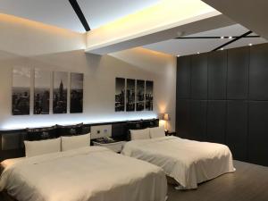 2 Betten in einem Hotelzimmer mit weißer Bettwäsche in der Unterkunft Kai-Hong Motel in Longtan