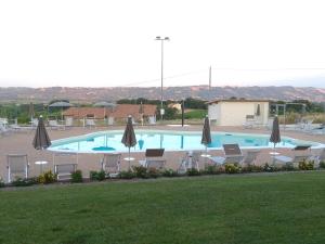 una grande piscina con sedie e ombrelloni di Hotel Residence Eden a Mozzagrogna