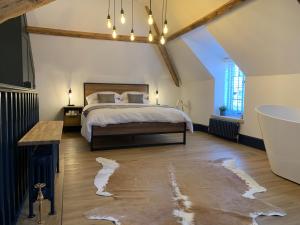 a bedroom with a large bed and a bath tub at The Old Post Office in Whitby