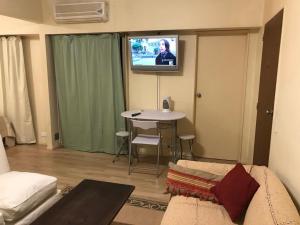 ein Wohnzimmer mit einem Sofa und einem Tisch mit einem TV in der Unterkunft ApartFlorida3 in Buenos Aires