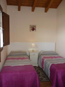 2 camas en una habitación con sábanas moradas en Casa El Campo Mateo, en Peruyes