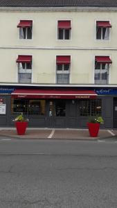 a building with red awnings on the side of a street at Le Maryland in Blanzy