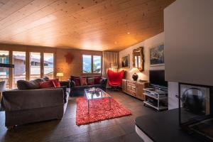 a living room with a couch and a table at Chalet Bella Vista 4 in Wengen