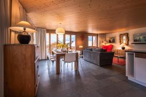 a kitchen and living room with a table and a couch at Chalet Bella Vista 4 in Wengen