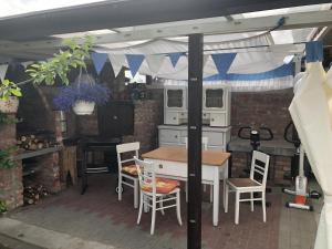 patio con mesa y sillas y cocina en Apartamenty i Pokoje Na Letniej, en Darłowo