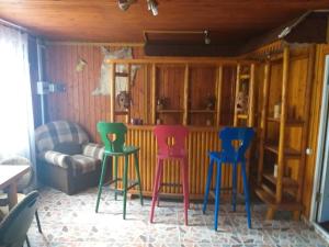 three colorful stools in a room with a couch at Rustic Country House in Snagov in Snagov