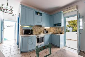 a kitchen with blue cabinets and a table at Casa Bianca in Antiparos Town