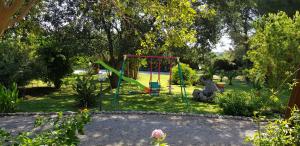 a playground in a park with a swing at La Macchia in Melendugno