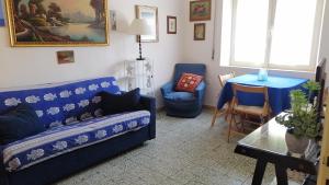 een woonkamer met een blauwe bank en een tafel bij Casa Vacanze La Terrazza Castiglione della Pescaia in Castiglione della Pescaia