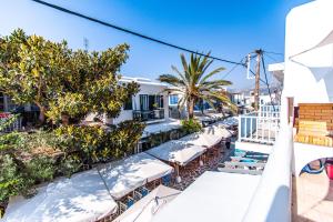 een balkon van een hotel met tafels en bomen bij Casa Bianca in Antiparos Stad